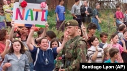 Pritja e trupave britanike të NATO-s nga qytetarët në Prishtinë. Qershor, 1999.
