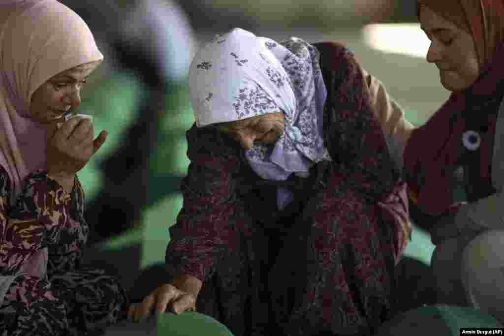 Нума Јахиќ тагува покрај ковчегот со посмртните останки на нејзиниот син, кој е меѓу 50-те новоидентификувани жртви на геноцидот во Сребреница во Поточари, Босна, 10 јули 2022 година. Илјадници луѓе се собраа во источниот босански град Сребреница за да ја одбележат годишнината од 27-та Единствениот признат геноцид во Европа по Втората светска војна. (AP Photo/Армин Дургут)