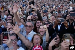 Люди реагируют на появление новоизбранного папы Льва XIV на балконе базилики Святого Петра в Ватикане, 8 мая 2025 года