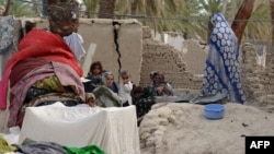 Пакистан - семејство седи пред нивната урната куќа во земјотресот.