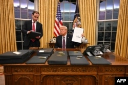 Trump semnează teancuri de ordine executive în Biroul Oval, pe 20 ianuarie 2025.