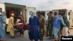 Талибански војници и цивили пренесуваат жртви на аеродромот во Џалалабад 