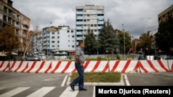 Një qytetar duke kaluar pranë barrierës që ndanë Mitrovicën jugore dhe veriore