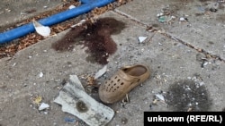 Obiecte personale împrăștiate pe locul unde o rachetă rusească a lovit pensionarii care stăteau la coadă în satul Iarova pe 9 septembrie.