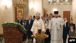 Fotografie distribuită de agenția de stat rusă Sputnik: Vladimir Putin participă, alături de rude ale soldaților ruși uciși în Ucraina, la o slujbă de Crăciun , 7 ianuarie 2024. (Foto: Mikhail VOSKRESENSKIY / POOL / AFP)