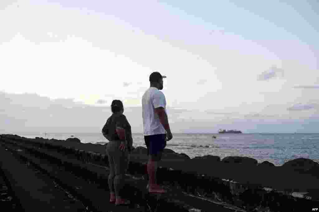 Par posmatra okean u Apiji, glavnom gradu Samoe, 30. jula 2025., dok je na snazi upozorenje na cunami.