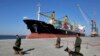 FILE: Security guards with their sniffer dogs patrol in front of a cargo ship during the inauguration ceremony of the newly built extension in the port of Chabahar in southeastern Iran (December 2017).
