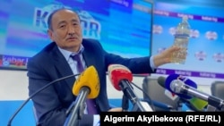Алымкадыр Бейшеналиев держит в руках бутылку с отваром иссык-кульского корня. 16 апреля 2021 года.