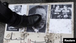 Demonstrant gazi plakat sa Mubarakovom fotografijom, 4. februar 2011