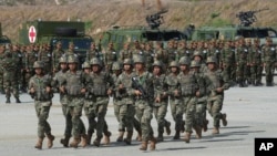 Chinese military personnel run in front of Cambodian soldiers as part of a joint military exercise in 2024.