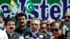 Pakistani President Arif Alvi (C) speaks, along with other leaders, during a rally organized to show their solidarity with people of Indian-administered Kashmir, on a street in Islamabad on August 5.