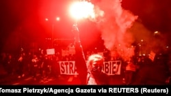 Fáklyát tart a kezében az abortuszt gyakorlatilag megtiltó alkotmánybírósági ítélet ellen tüntetők egyike a lengyelországi Wroclawban, 2020. október 26-án