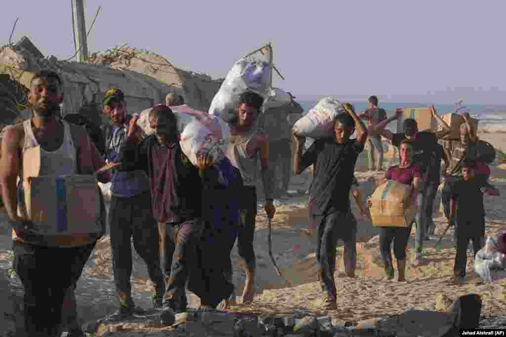 Banorë të Gazës të ngarkuar me ndihma.