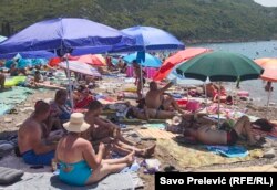 Pushuesit në kërkim të hijes në një plazh në Tivar.