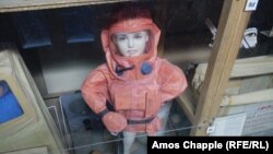 Një kukull si fëmijë veshur me kostum kundër rrezatimit brenda një strehimoreje bërthamore në Pragë.