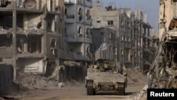 Израелски танк на фона на разрушени сгради в Ивицата Газа.