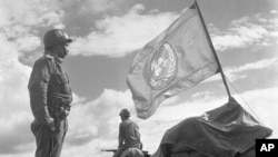 Doi soldați din cadrul Forțelor de Urgență ale Națiunilor Unite stau de pază la un avanpost din banda Gaza, între Egipt și Israel, 15 noiembrie 1957. UNEF, alcătuit din trupe din Brazilia, Canada, Columbia, Danemarca, Finlanda, India, Indonezia , Norvegia, Suedia și Iugoslavia, au păstrat pacea în regiune timp de un an.