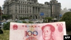 Купюра в сто юаней на фоне здания банка в Шанхае. 21 мая 2007 года.