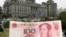 Купюра в сто юаней на фоне здания банка в Шанхае. 21 мая 2007 года.