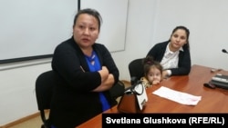 Анар Кульжанова (слева), сестра заключенного Марата Кульжанова, и его жена Инкар Жолболдиева с дочерью. Астана, 10 июля 2015 года.