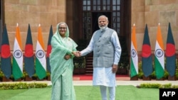 Indijski premijer Narendra Modi (desno) rukuje se sa koleginicom iz Bangladeša šeikom Hasinom po njenom dolasku u Nju Delhi, 22. jun 2024.