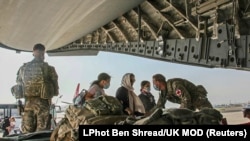 Shtetasit britanikë dhe disa afganë duke u larguar nga shteti përmes aeroportit të Kabulit Gusht 2021.