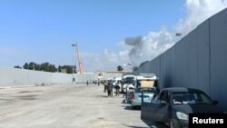 Egipatski dobrovoljci gledaju dim koji se diže s palestinske strane na prelazu Rafah, dok grupe pomoći čekaju na ponovno otvaranje granice. Egipat, 17. oktobra 2023.