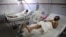 Afghan men who were injured in a suicide car bomb blast in Paktika province receive medical treatment after being transferred to a hospital in Kabul, July 16, 2014.
