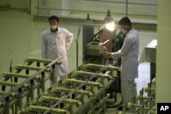 Iran: Dy teknikë duke punuar në një ndërtesë ku prodhohet uraniumi për reaktorët bërthamor. Foto nga arkivi.