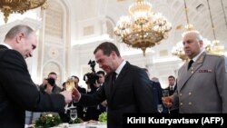 Наздравица между Владимир Путин и премиера Дмитрий Медведев пред Сергей Суровикин, след церемония за връчване на държавни награди на военнослужещи в Сирия - Кремъл, 2017 г.