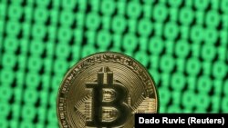 Un Bitcoin pe un ecran de computer