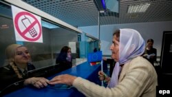 O moldoveancă, prezemtănd pașaportul la Aeroportul Internațional Chișinău, pe 28 aprilie 2014, înainte de primului zbor fără viză a unor cetățeni moldoveni spre o țară UE, un zbor spre Atena, Grecia.