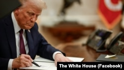 Президентът на САЩ Доналд Тръмп подписва изпълнителни заповеди в Овалния кабинет на Белия дом във Вашингтон, 20 януари.