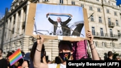 Átrajzolt Orbán-képet tartó tüntető Budapesten, 2021. június 14-én.