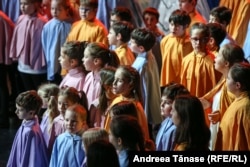 Copii din Programul Cantus Mundi, îmbrăcați în pelerine colorate, cântă în timpul spectacolului „Pe drumul Crăciunului”.