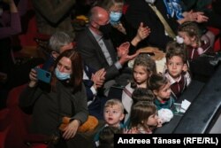O femeie își face un selfie cu copii din Programul Cantus Mundi, în timpul spectacolului „Pe drumul Crăciunului”, la Opera Națională din București.