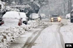 Автомобили са затрупани от сняг вследствие на обилния снеговалеж в Троян, 26 декември 2024 г.