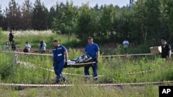 Служители на руските служби носят тялото на бившия транспортен министър на Русия Роман Старовойт, 7 юли 2025 г.