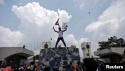 Učesnik protesta maše zastavom Nepala na ulazu u parlament, Katmandu, 8. septembar 2025.