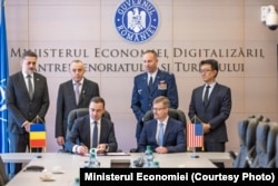 Ministrul Economiei, Bogdan Ivan, semnează scrisorile de solicitare în prezența însărcinatului pentru afaceri al SUA, Michael Dickerson.