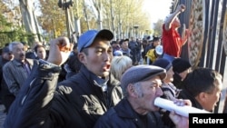 Родственники погибших в апреле при столкновениях в Кыргызстане протестуют у ворот здания парламента во время его первого заседания. Бишкек, 10 ноября 2010 года.