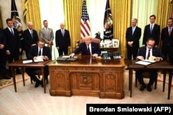 Ish-kryeministri i Kosovës, Avdullah Hoti dhe presidenti i Serbisë Aleksandar Vuçiq, duke nënshkruar marrëveshjen për normalizimin e marrëdhënieve ekonomike, në praninë e ish-presidentit të SHBA-së, Donald Trump në Shtëpinë e Bardhë, më 4 shtator 2020.