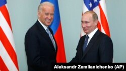 Then-U.S. Vice President Joe Biden (left) shakes hands with Putin, who was then Russian prime minister, in Moscow on March 10, 2011.