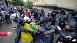 A rendőrség megpróbál őrizetbe venni egy tüntetőt az „orosz törvény” elleni ellenzéki tüntetésen a georgiai Tbiliszi központjában 2024. május 13-án