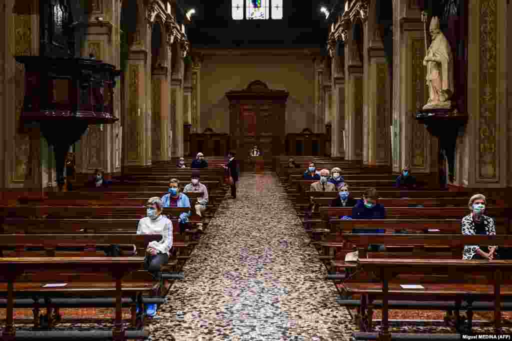 Луѓе кои носат маска за лице присуствуваат на утринска миса во црквата Сан Бјаџо и Санта Марија Имаколата на 20.05 2020 година во Кодоно, југоисточно од Милано, едно од селата на епицентарот на епидемијата на коронавирус во февруари.