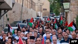 Creștini palestinieni din satul Jifna, la nord de Ramallah, in Cisiordania, își exprimă solidaritatea cu palestinenii din Gaza la 23 octombrie 2023, pe fondul luptelor dintre Forța de Apărare Israeliană și milițiile Hamas. (Foto: AFP) 