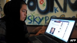 O femeie afgană într-o cafenea de internet la Kabul, înainte de preluarea puterii de către talibani în 2021.