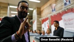 Sirijac pokazuje mastilo na prstu tokom glasanja na predsedničkim izborima u Damasku, 26. maj 2021. 
