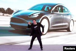 Elon Musk dansează pe scenă în timpul unui eveniment de livrare a mașinilor Tesla Model 3 fabricate în China, Shanghai, 7 ianuarie 2020.
