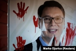 Portreti i presidentit të Serbisë, Aleksandar Vuçiç, në selinë e SNS-së është ngjyrosur me bojë të kuqe dhe me shenjat e duarve që simbolizojnë sloganin "duart tuaja janë të gjakosura", gjatë protestës së parë të mbajtur në Novi Sad më 5 nëntor 2024.